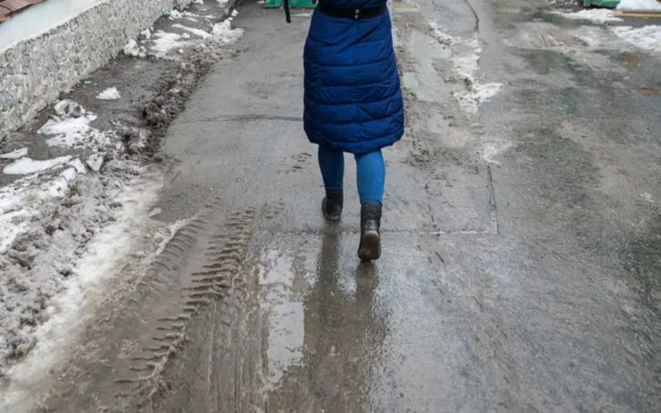 Frau, die durch Schneematsch läuft