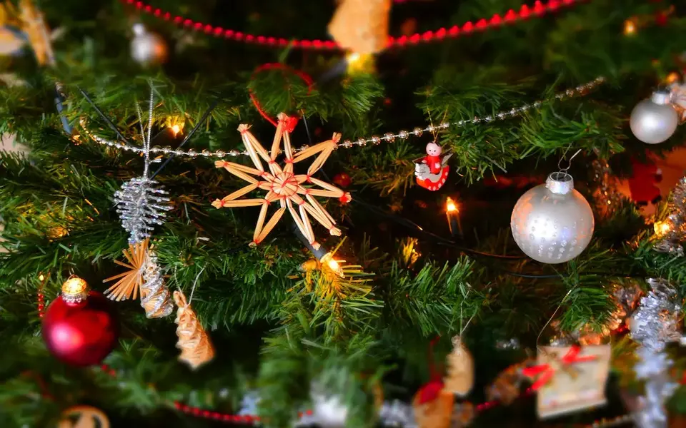 Weihnachtliches Hintergrundbild mit Tannenzweigen, Strohsternen und Kugeln