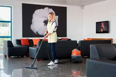 G&M Reinigungskraft beim Saugen eines Aufenthaltsraums