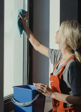 Gebäudereinigerin bei der Fensterreinigung