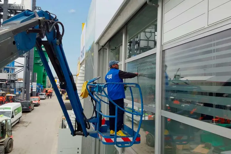 Glasreinigung an einem Gewerbegebäude mit Arbeitsbühne