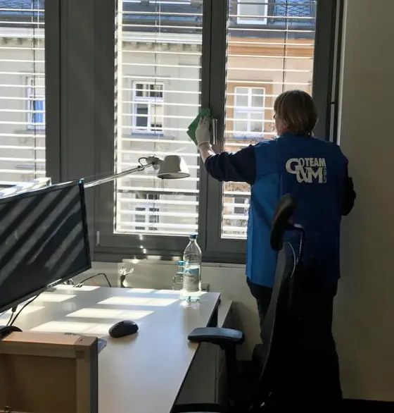 G&M Mitarbeiterin bei der Fensterreinigung in einem Münchner Büro