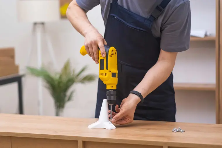 Handwerker bei einer Bohrarbeit im Rahmen des Objektservices