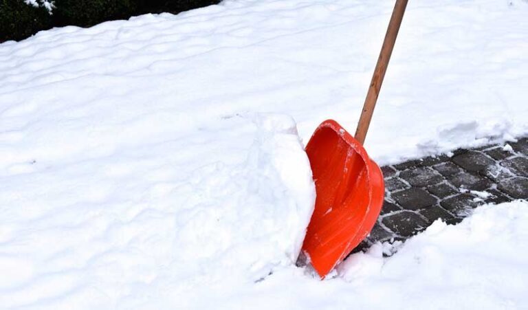 Gehweg wird mit Schneeschaufel geräumt