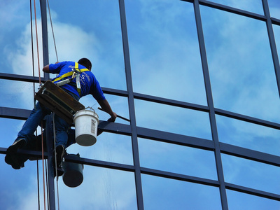 Ein Mitarbeiter unserer Reinigungsfirma bei der Reinigung einer Glasfassade Ein Mitarbeiter unserer Reinigungsfirma bei der Glasreinigung