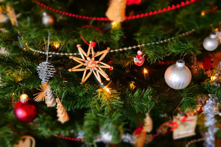 Weihnachtliches Hintergrundbild mit Tannenzweigen, Strohsternen und Kugeln